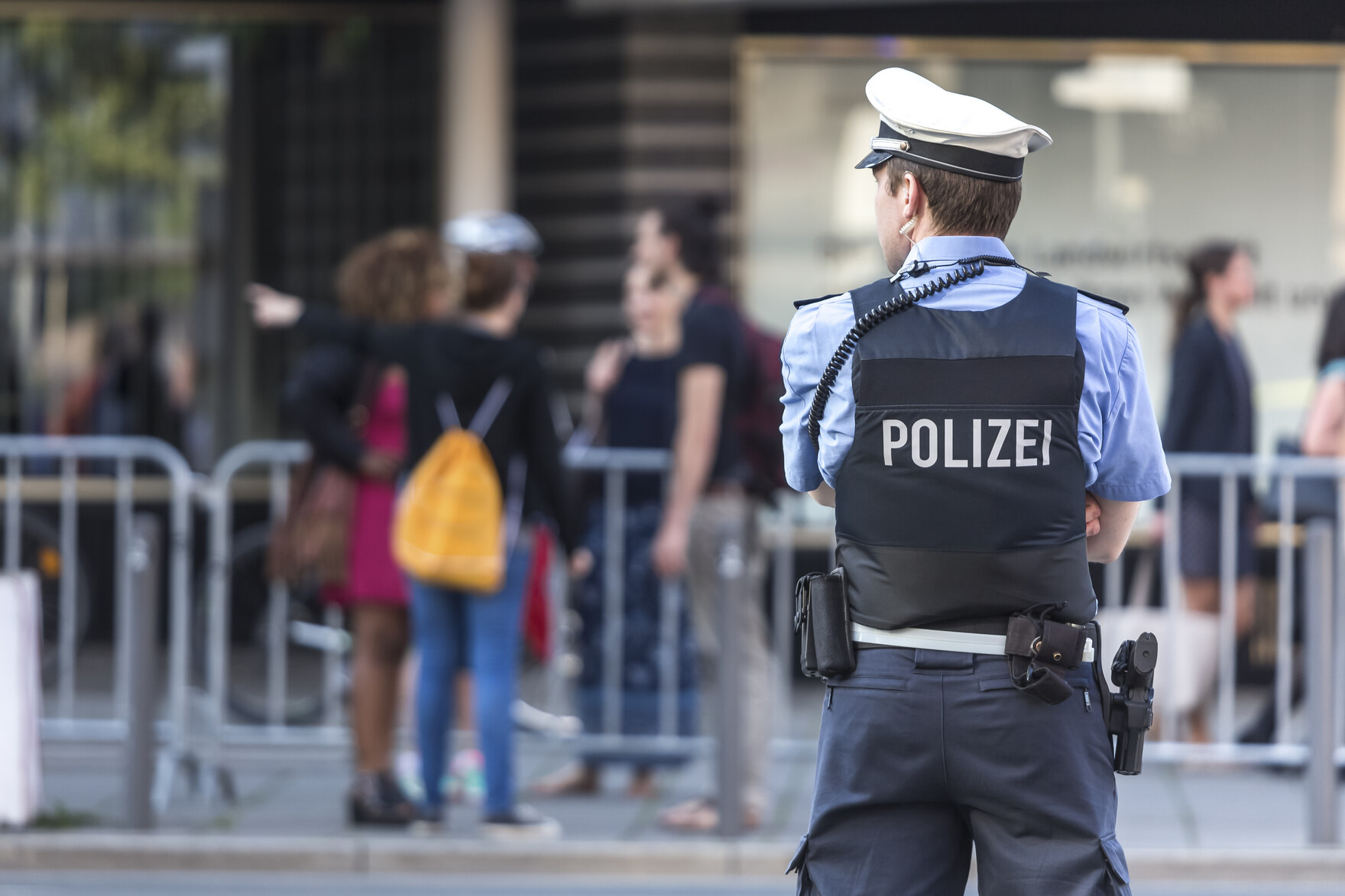 Ein Polizist steht vor einer Gruppe junger Menschen.