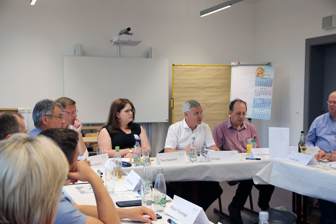 Mehrere Menschen sitzen an einem Tisch.