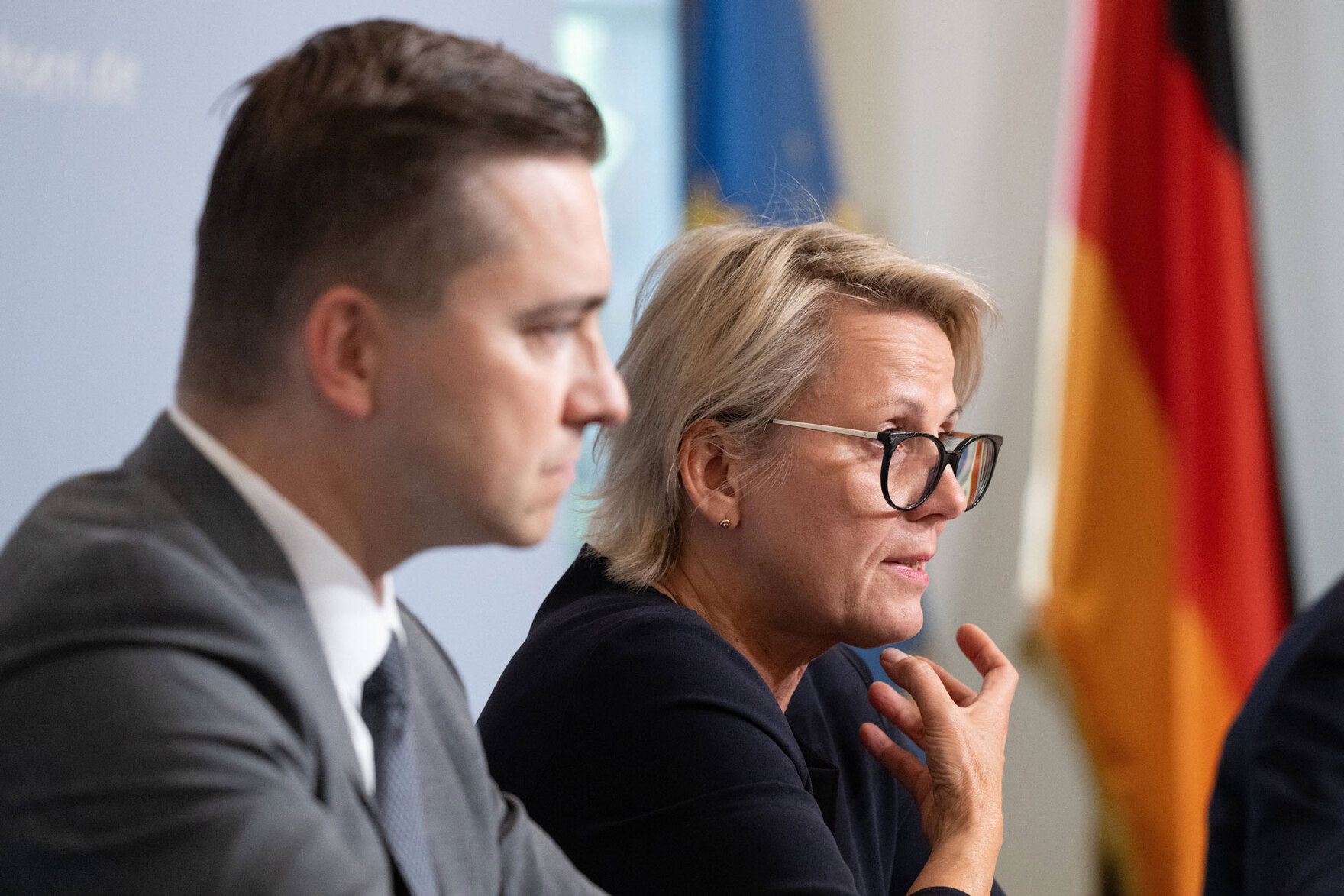 Eine Frau und ein Mann sprechen auf einer Pressekonferenz.