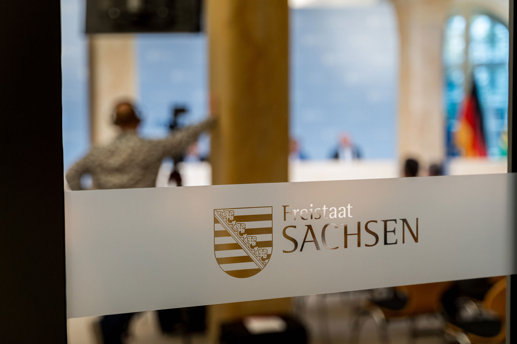 Auf einer Glastür steht »Freistaat Sachsen«. Hinter der Glastür findet die Kabinettspressekonferenz statt.