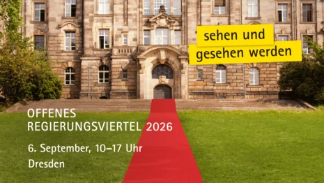 Ein roter Teppich verläuft zum Eingang eines alten Gebäudes.