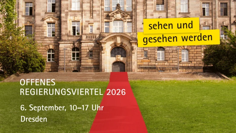Ein roter Teppich verläuft zum Eingang eines alten Gebäudes.