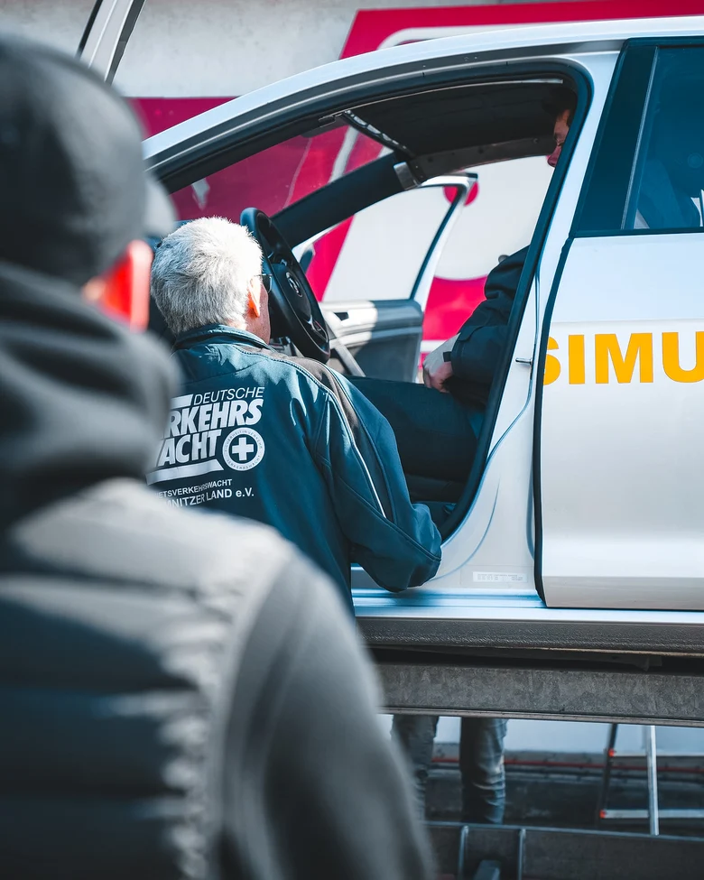 Personen an einem Fahrsimulator