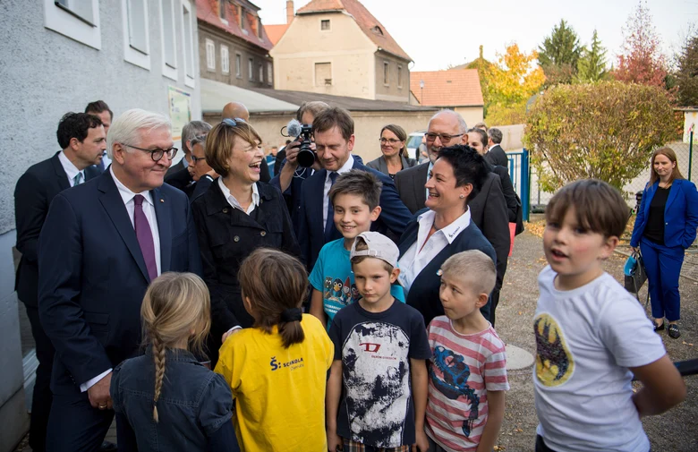 Männer und Frauen sind von kleinen Kindern umgeben.