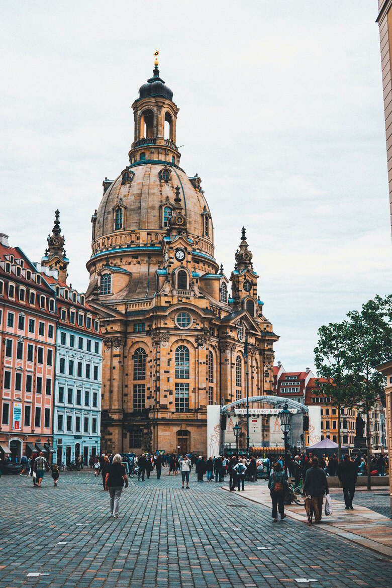 Menschen stehen auf einem Platz vor einer großen Kirche.