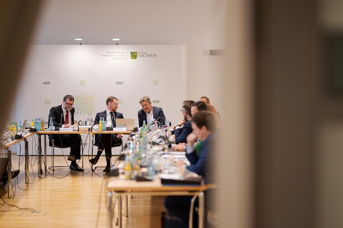 Männer sitzen an einem Konferenztisch und unterhalten sich.