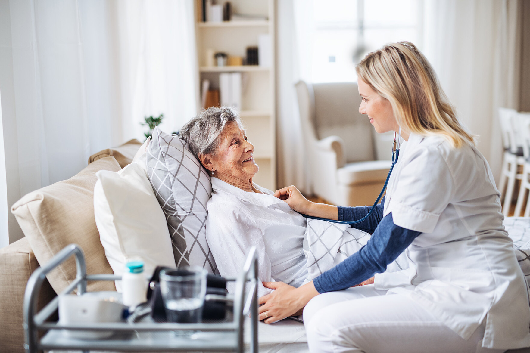 Eine Ärztin behandelt eine Patientin, die in einem Bett liegt.