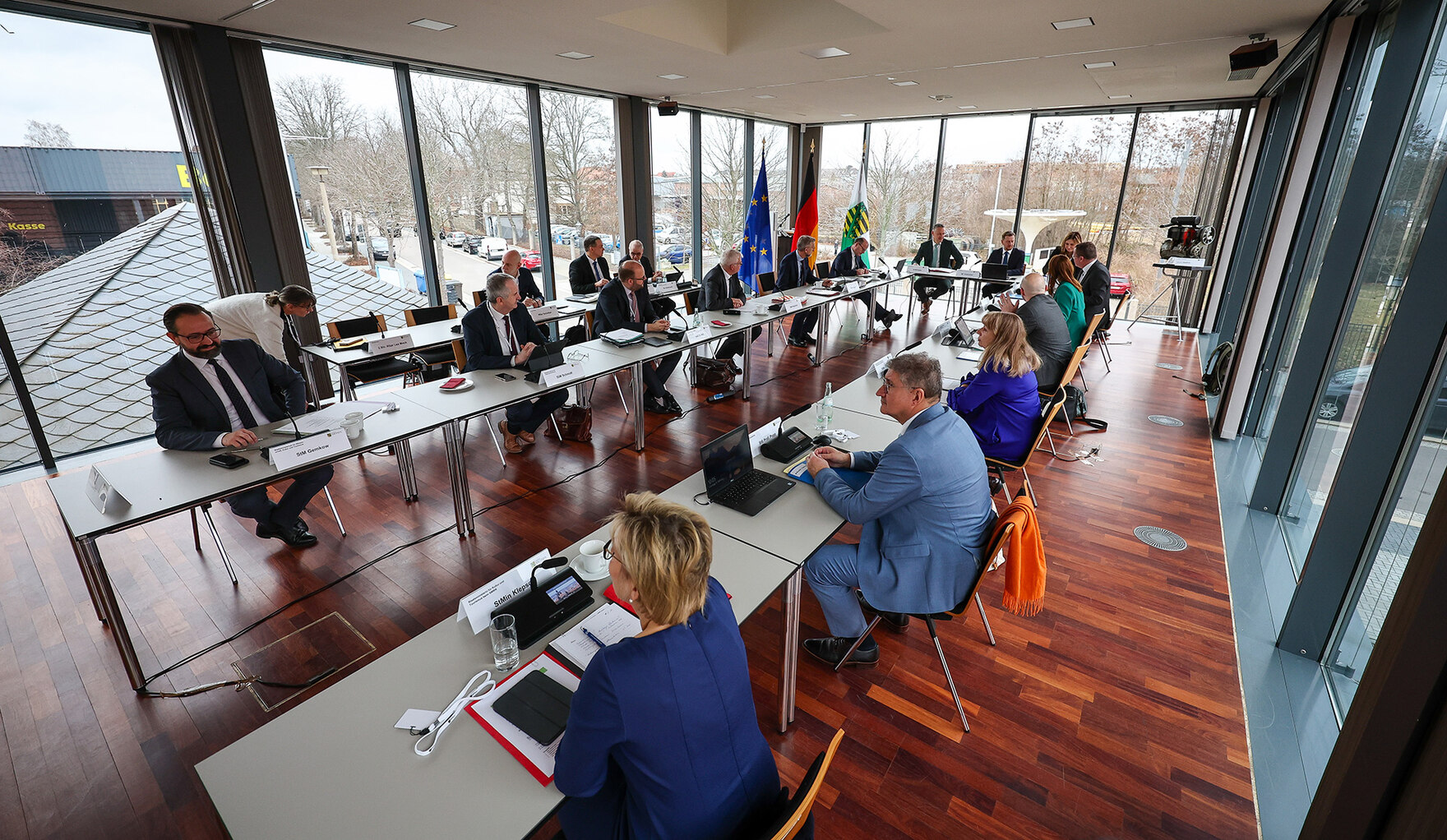 Männer und Frauen sitzen an einem Konferenztisch.