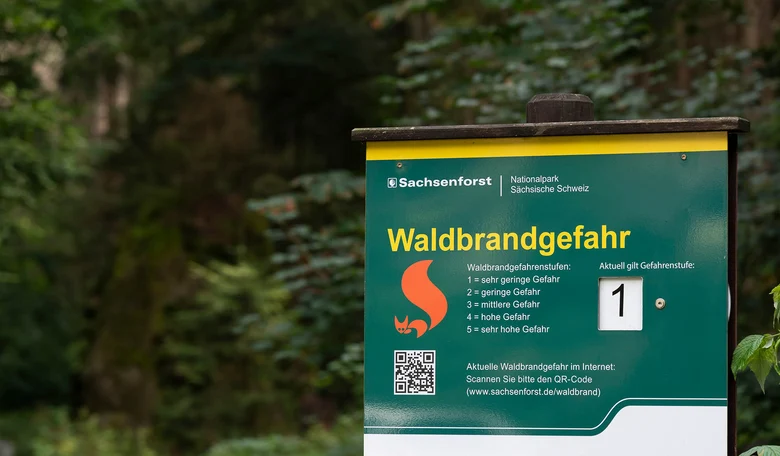Ein Waldbrandwarnschild des Sachsenforst mit der Stufe 1.