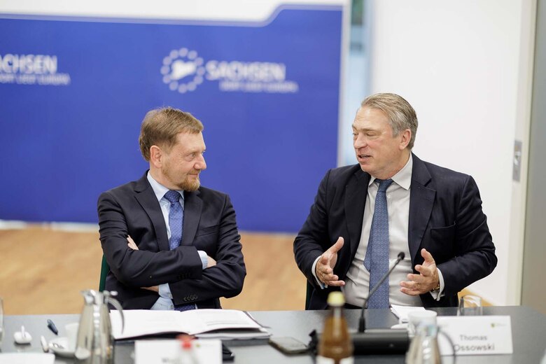 Zwei MKänner sitzen an einem Tisch