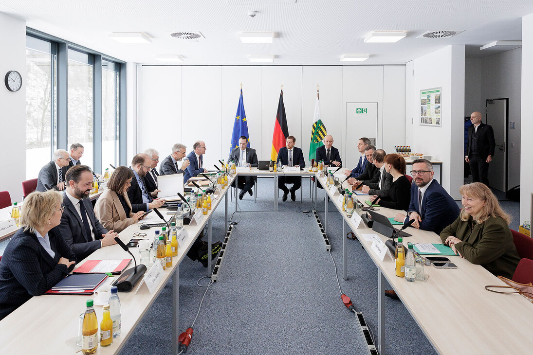 Männer und Frauen halten eine Konferenz ab.