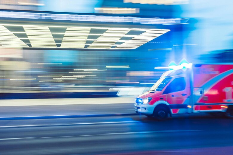 Ein Krankenwagen fährt vor einem Krankenhaus.