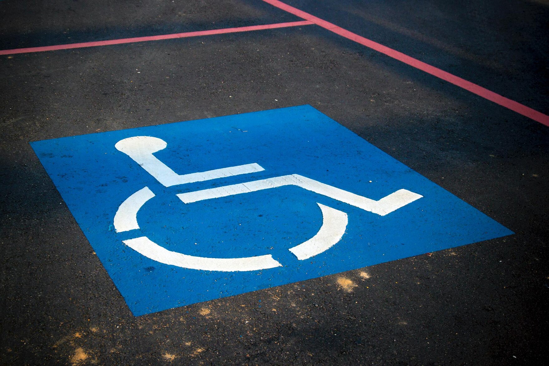 Ein Rollstuhlsymbol auf einem Parkplatz.
