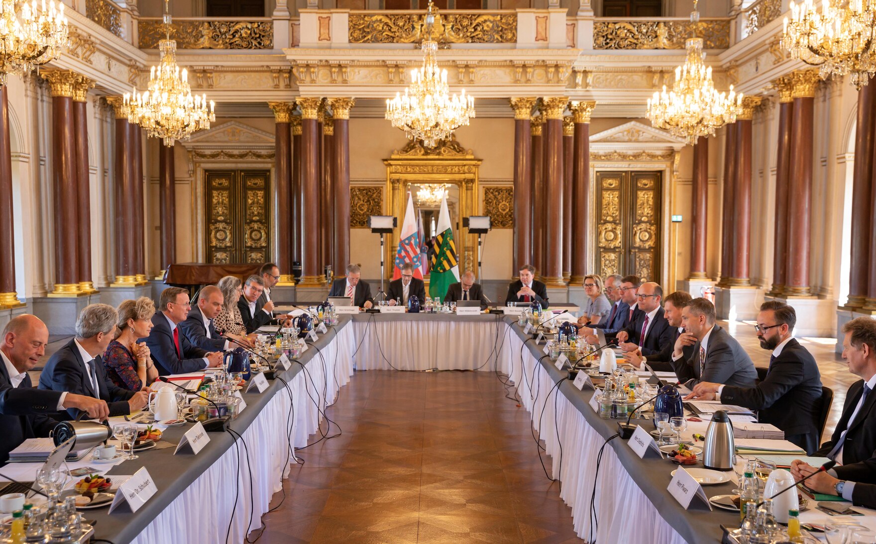 Eine Gruppe von Menschen sitzt in einem großen Sitzungssaal.