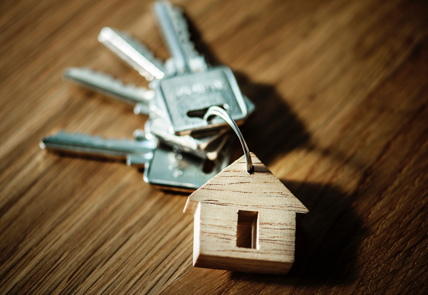 Ein Schlüsselbund mit einem kleinen Holzanhänger in Hausform.