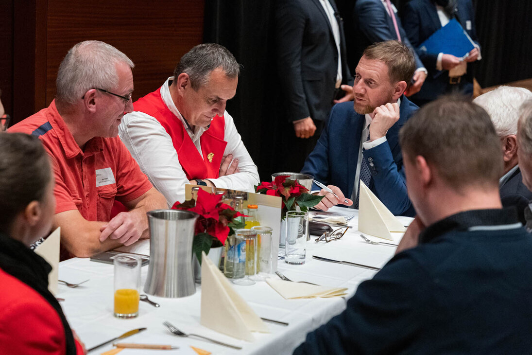 Männer sitzen an einem Tisch und unterhalten sich.